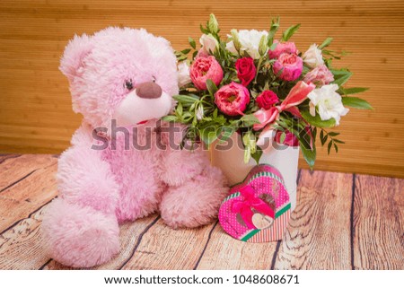teddy bear, a bouquet of flowers and a gift