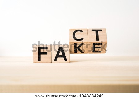 Business and design concept - surreal abstract geometric wooden cube take by hand with word " FACT & FAKE " concept on wood floor and white background Royalty-Free Stock Photo #1048634249