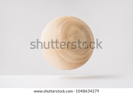 Design concept - abstract real wooden sphere with surreal layout on white surface background and it's not 3D render