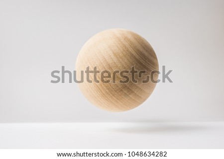 Design concept - abstract real wooden sphere with surreal layout on white surface background and it's not 3D render