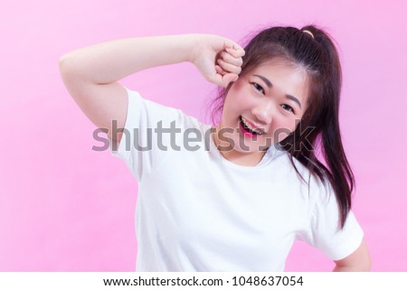 Portrait of beautiful Young Asian woman black hair wear a white t-shirt isolated on pink background. Cute lovely girl looking at camera with adorable smile.