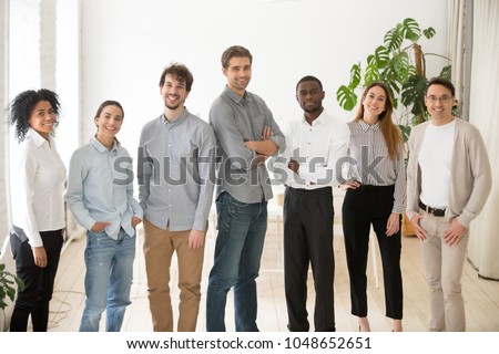 Young happy multiracial professionals or company staff looking at camera smiling, multi-ethnic group of diverse business people standing together, employees posing in office, successful team portrait Royalty-Free Stock Photo #1048652651