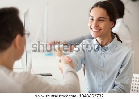 Happy hired intern, successful student, promoted woman employee smiling shaking boss hand congratulating worker for good work result, appreciating supporting young motivated professional by handshake Royalty-Free Stock Photo #1048652732