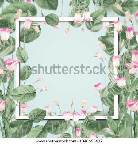Beautiful botanical frame with pink flowers and leaves at pastel blue background. Creative layout with copy space for design