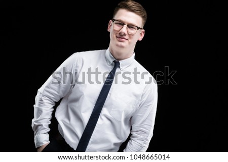 Portrait of confident handsome elegant responsible businessman with hands in pockets on black background