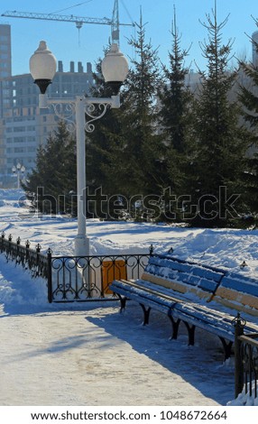 Benches in the winter city Park Covered with snow.