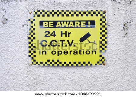 Be aware 24 hr cctv security in operation sign yellow black on wall