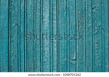 Wooden wall covered by distressed green paint.