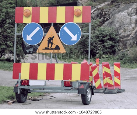 Fences and signs of carrying out repair work on road. Sign road works - Workers ahead