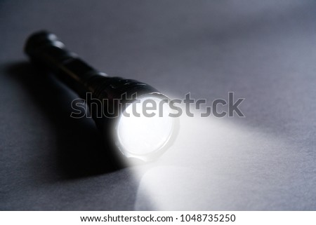Flashlight and beam of light on a dark background Royalty-Free Stock Photo #1048735250