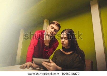 Man and woman discussing over digital laptop in creative office
