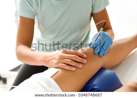 Electroacupuncture dry with needle connecting machine used by acupunturist on female patient for acupuncture guided by EPI Intratissue Percutaneous Electrolisis.  Royalty-Free Stock Photo #1048748687
