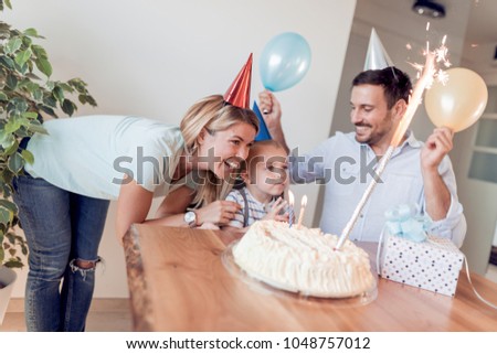 Birthday.Little boy blows out candles on birthday cake.Happy family celebrating birthday.