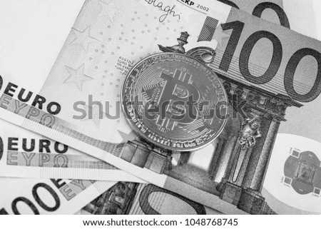 Gold bat against the background of the European currency. The Cryptocurrency Bitcoin
