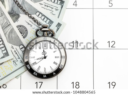 Pocket watch with money on the calendar. Time is money. Royalty-Free Stock Photo #1048804565