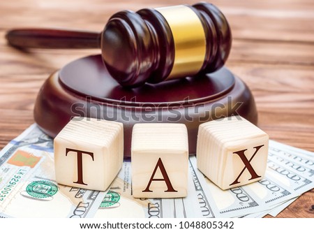 Tax law concept. Word " TAX " with gavel and money on the table. Royalty-Free Stock Photo #1048805342