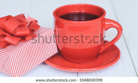 gift box and red Cup on a light wooden background