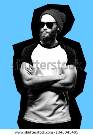 A hipster man with glasses and a hat looks away dressed in a white T-shirt with an empty space for your logo or inscription