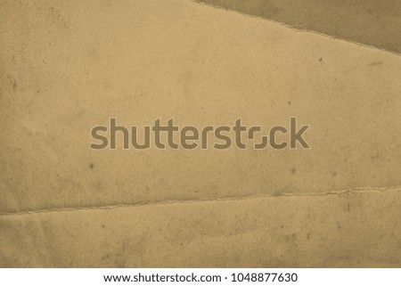 Blank aged paper sheet as old dirty frame background with dust and stains. Front view. Vintage and antique art concept. Detailed closeup studio shot. Sepia toned