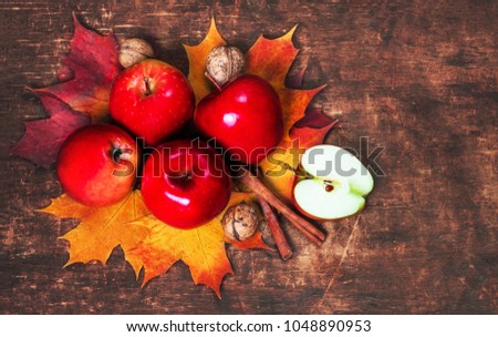  Harvest Background with red ripe apples and marple leaves on wooden table with copy space. Seasonal autumnal concept