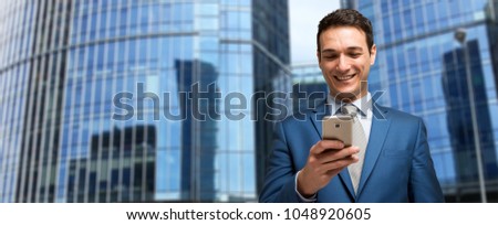 Smiling businessman using his cellphone