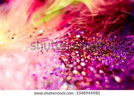 Soft feather with sparkles with artistic bright light and shadows. Soft blurred background of artistic close-up glitter macro image.