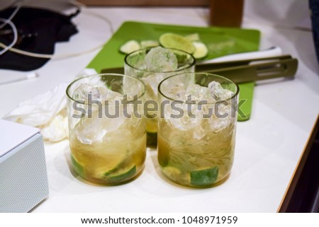 Brazilian caipirinha drinks on table.  Made of lime, cachaca, sugar, and ice.