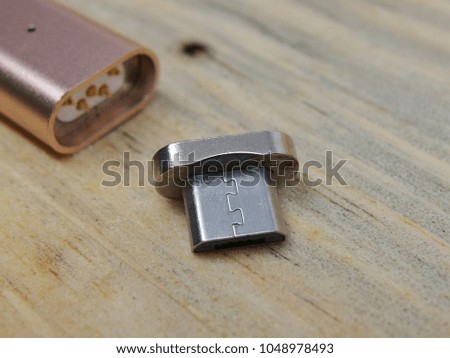 metal rose gold usb data cable charger with magnetic adaptor on wood planks background