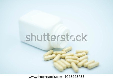 close up pill put near white box on isolated white background