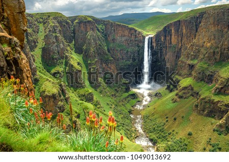 Maletsunyane Falls in Lesotho Africa. Most beautiful waterfall in the world. Green scenic landscape of amazing water fall dropping into a river inside canyons. Panoramic views over the great falls. Royalty-Free Stock Photo #1049013692