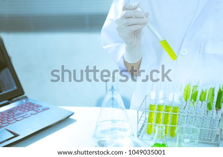 Female Scientist or Doctor With Green Solution In Laboratory - Stock Photo
A female doctor or medical examiner looking at a test tube of a green solution in a laboratory.