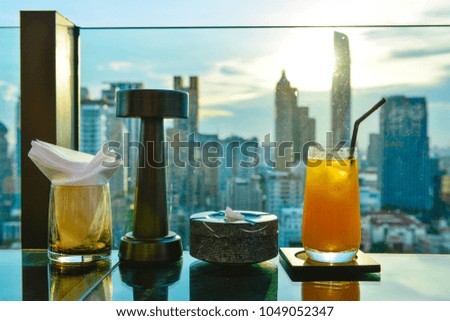 Orange juice glasses in Restaurant couch bar with view of Bangkok.