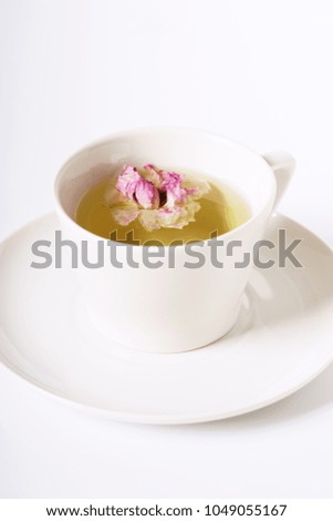 cup of herbal rose tea with dried roses
