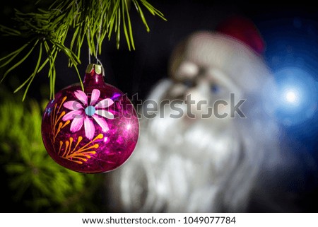 New Year's toy on a Christmas tree on a background of Santa Claus.