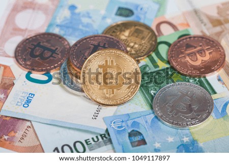 Golden Bitcoin cryptocurrency on Euro banknotes. New virtual money concept.