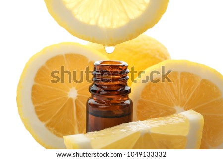 Dripping citrus essential oil into bottle on white background Royalty-Free Stock Photo #1049133332