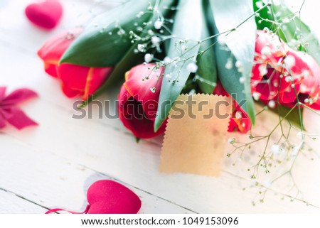 Red live tulips on a white wooden background