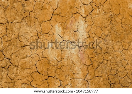top view cracked  red soil ground Earth for texture background,desert cracks,Dry Orange surface Arid,drought land,Picture of natural disaster. drought land Caused by global warming and deforestation.
