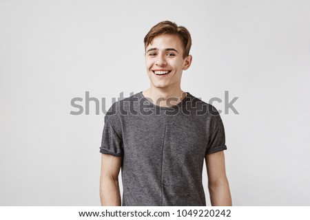 Handsome young brunette with kind eyes tries to use all his charm and beautiful smile to ask his boss for a day off. Women in an office can not resist him so he already thinks how to spend free day Royalty-Free Stock Photo #1049220242