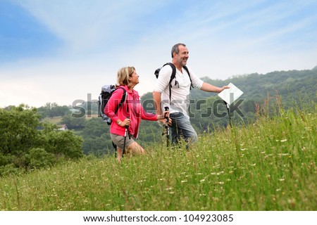 Senior couple hiking in natural landscape Royalty-Free Stock Photo #104923085