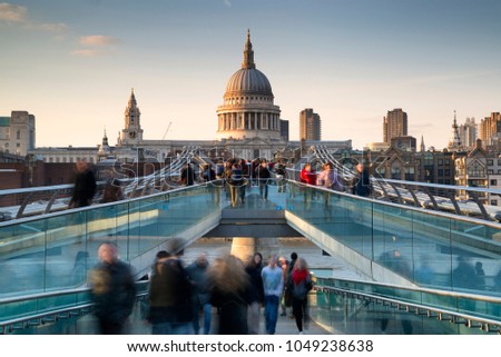 St Pauls Cathedral and the Millennium Bridge at sunset landscape with blurred tourists