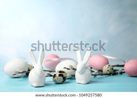 Composition with Easter bunnies and eggs on color background