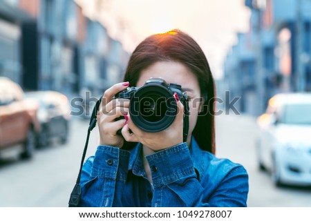 Photographer taking pictures with digital camera. Vintage tone.