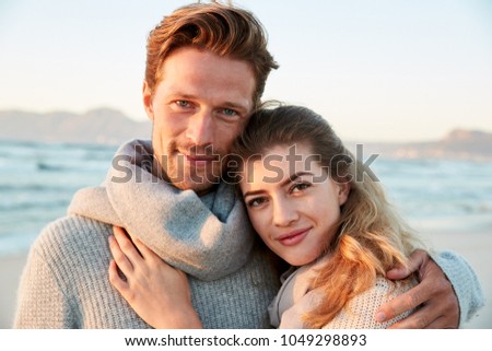 Portrait Of Loving Couple Walking Along Winter Beach Together