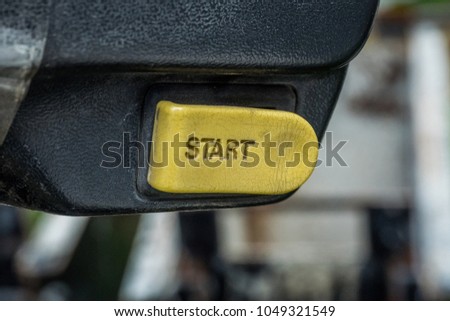 Engine Start Button. Old and dirty. pushed action start yellow button, motivation concept. car, moped and motorcycle interior, key, start&stop. 