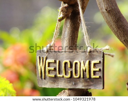 welcome sign hanging in the garden