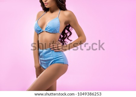 cropped view of beautiful girl posing in trendy bikini, isolated on pink