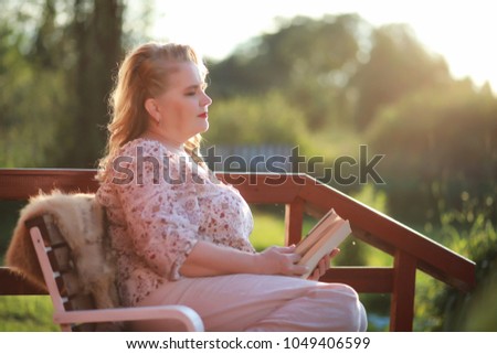 An elderly woman with an evening make-up on the porch of a country house