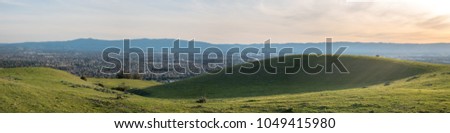 Wide Panorama of Green Fields With Downtown San Jose in the background at Sunset