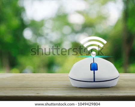 Wi-fi button with wireless computer mouse on wooden table over blur green tree in park, Technology and internet concept